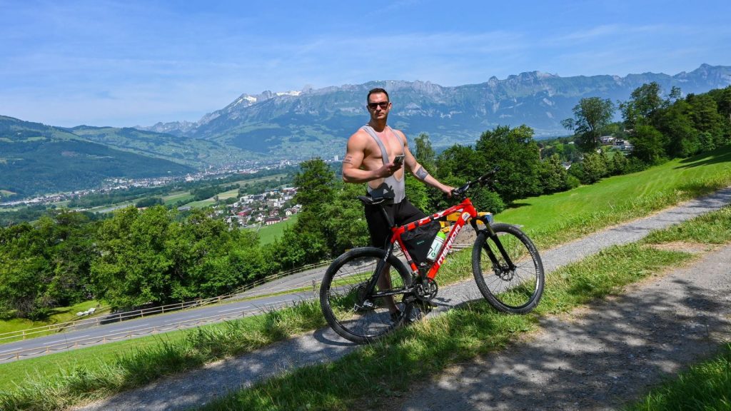 مرد بدنساز درحال دوچرخه سواری در کوهستان